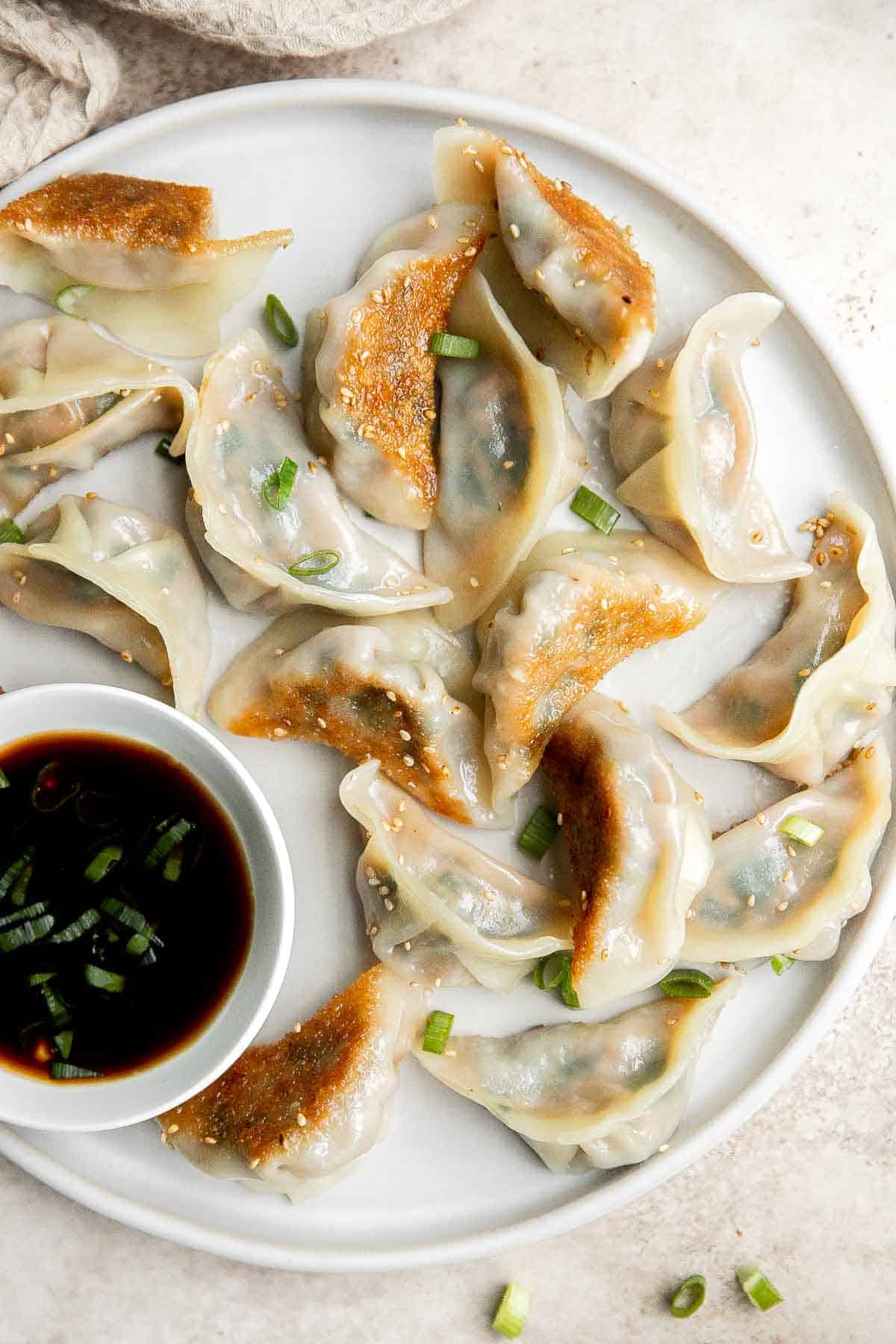 自制猪肉饺子既快捷又简单，底部酥脆可口，里面是鲜嫩多汁的猪肉馅。易于准备和冷冻。| aheadofthyme.com