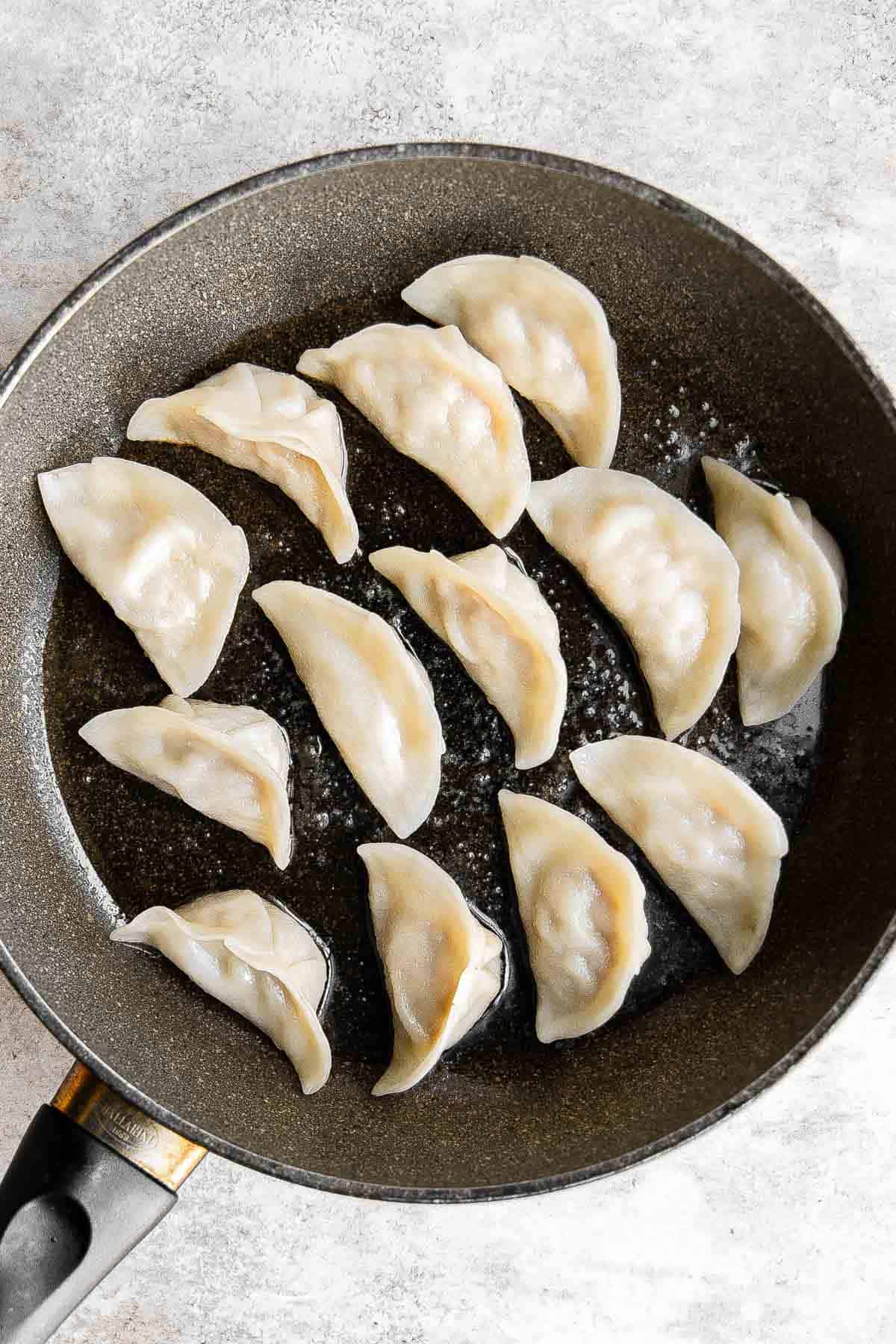 泡菜饺子是美味,美味,可口的。这些Korean-inspired饺子被烙印和蒸创造经典的脆皮底锅贴。| aheadofthyme.com