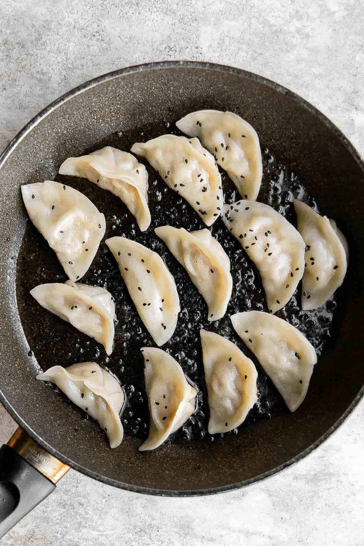 泡菜饺子是美味,美味,可口的。这些Korean-inspired饺子被烙印和蒸创造经典的脆皮底锅贴。| aheadofthyme.com