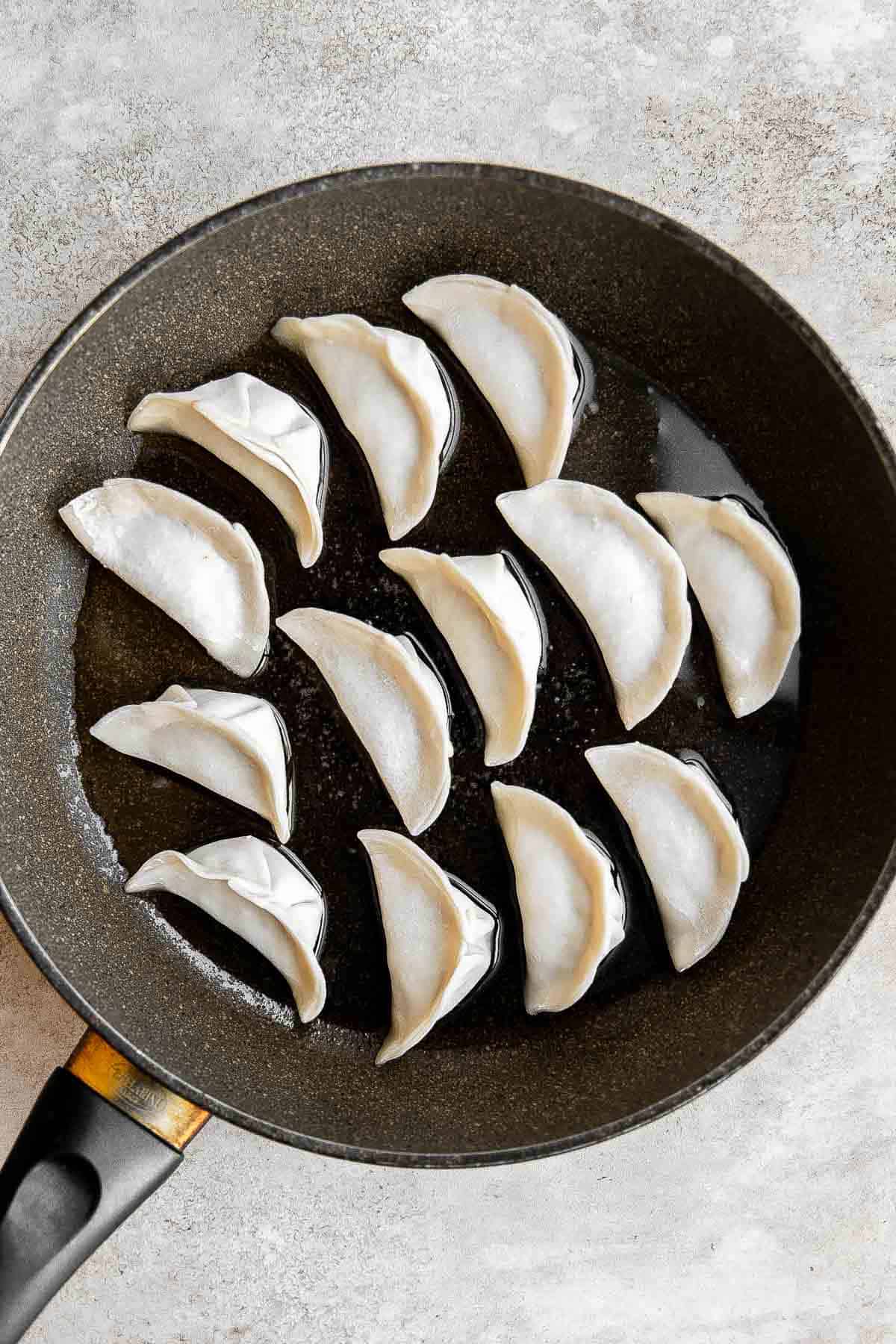 泡菜饺子是美味,美味,可口的。这些Korean-inspired饺子被烙印和蒸创造经典的脆皮底锅贴。| aheadofthyme.com