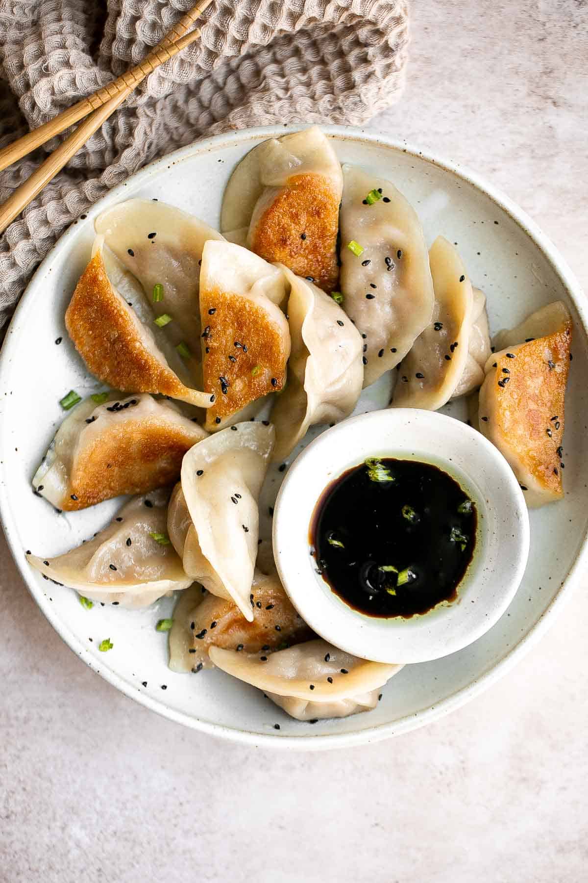 泡菜饺子是美味,美味,可口的。这些Korean-inspired饺子被烙印和蒸创造经典的脆皮底锅贴。| aheadofthyme.com